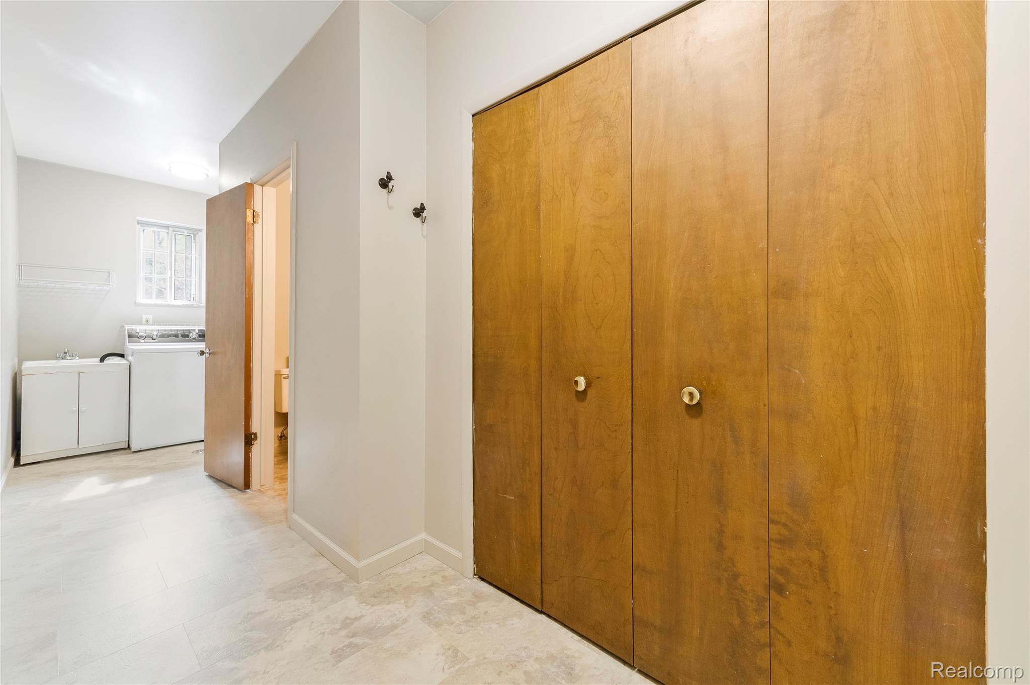 8887 Clark Road Clarkston, MI 48346 - Photo 15 of 40 Corridor featuring independent washer and dryer and light floors