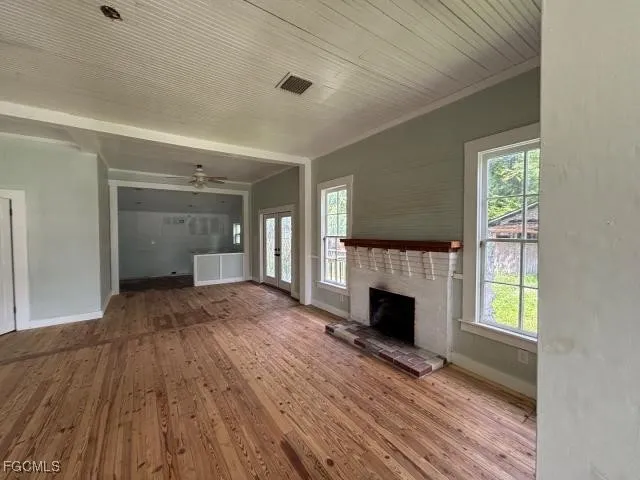 a view of empty room with wooden floor and fireplace