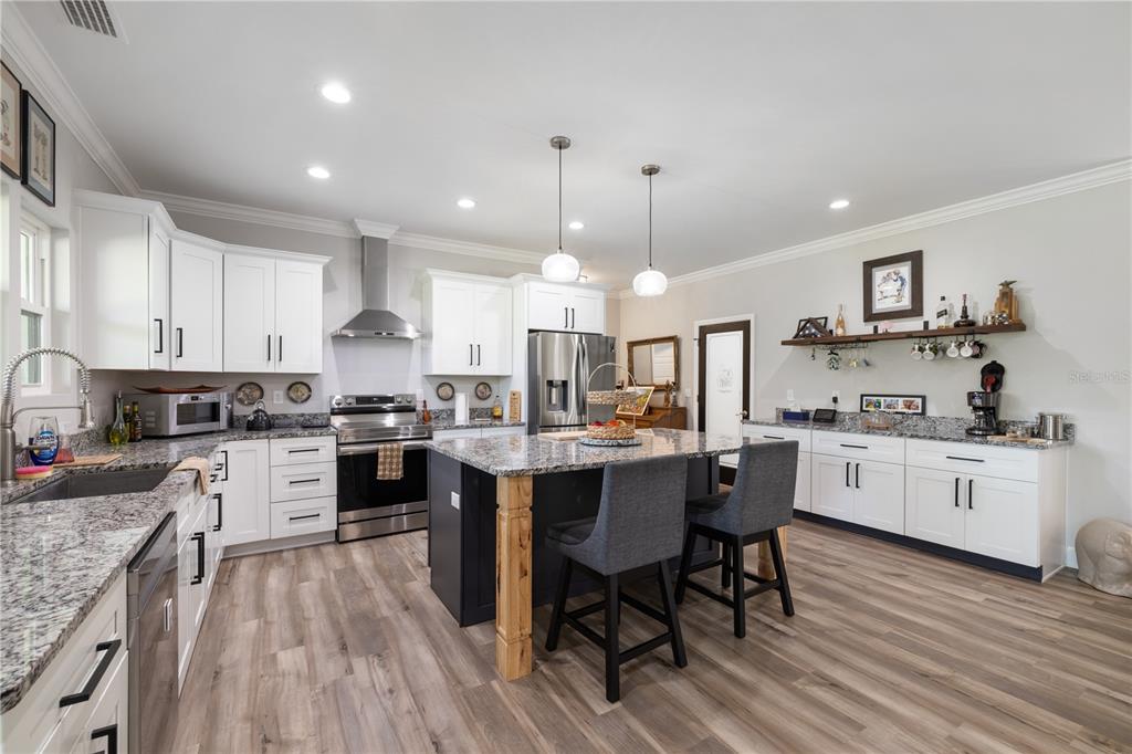 5149 Southwest 119th Road Lake Butler, FL 32054 - Photo 4 of 40 a large kitchen with granite countertop lots of counter space dining table and stainless steel appliances