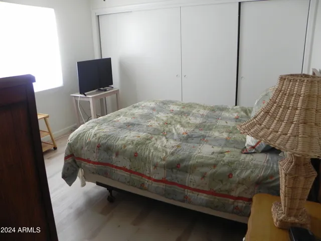 a bedroom with a bed tv and a chair