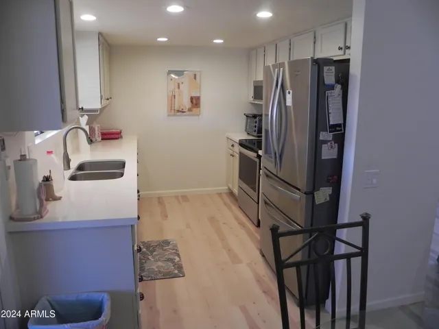 a kitchen with granite countertop a refrigerator and a sink