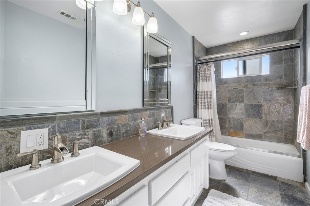 403 Beech Street Arroyo Grande, CA 93420 - Photo 28 of 46 a bathroom with a granite countertop sink a toilet and bathtub