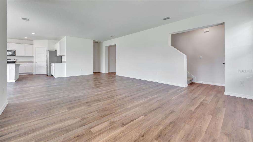 3598 Roden Road Haines City, FL 33844 - Photo 6 of 26 a view of an empty room with wooden floor and a kitchen