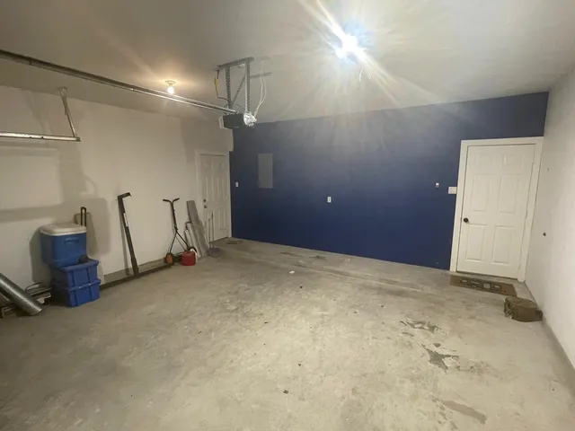 an empty room with wooden floor cabinet and windows