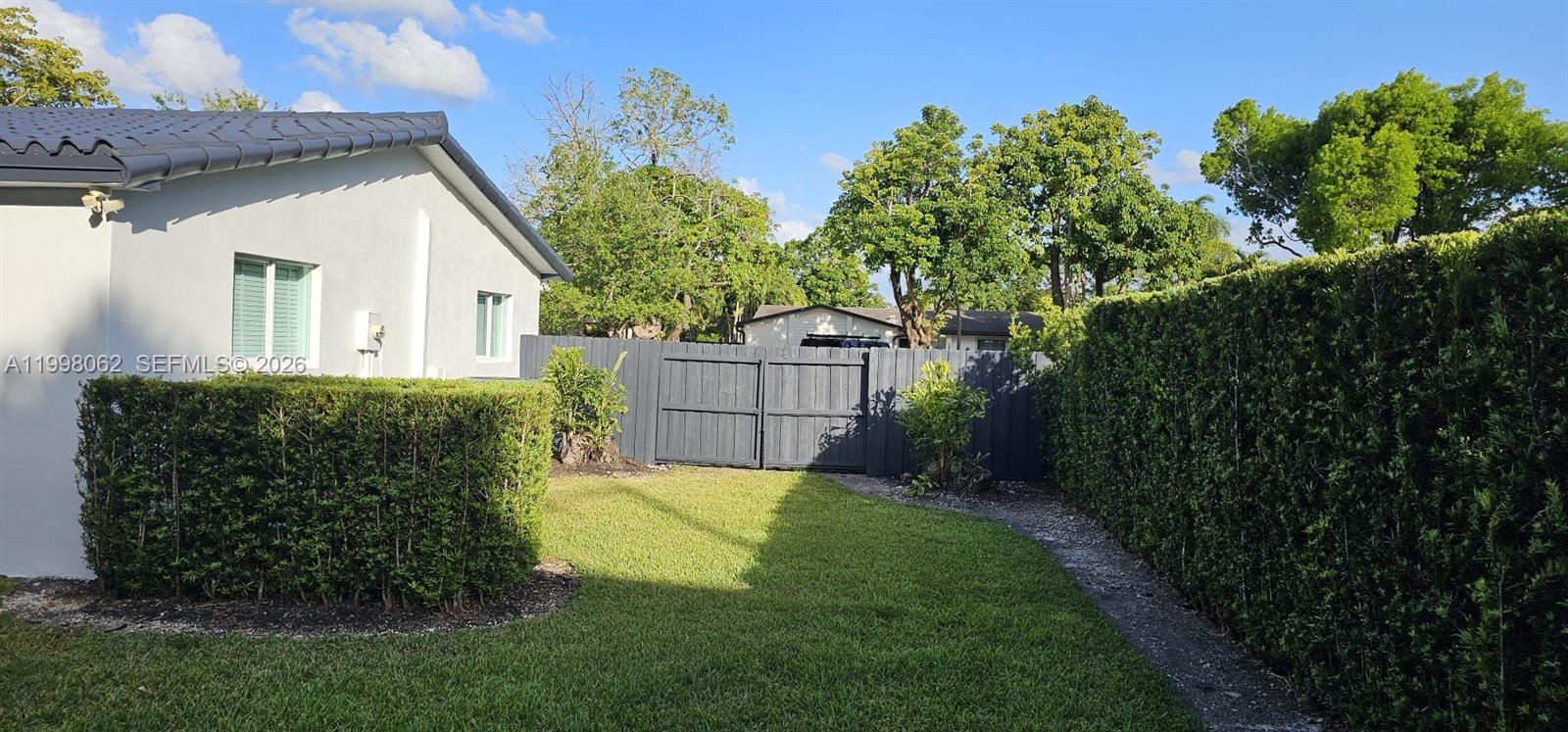 10900 Southwest 107th Avenue Miami, FL 33176 - Photo 24 of 26 a view of a house with a small yard and plants