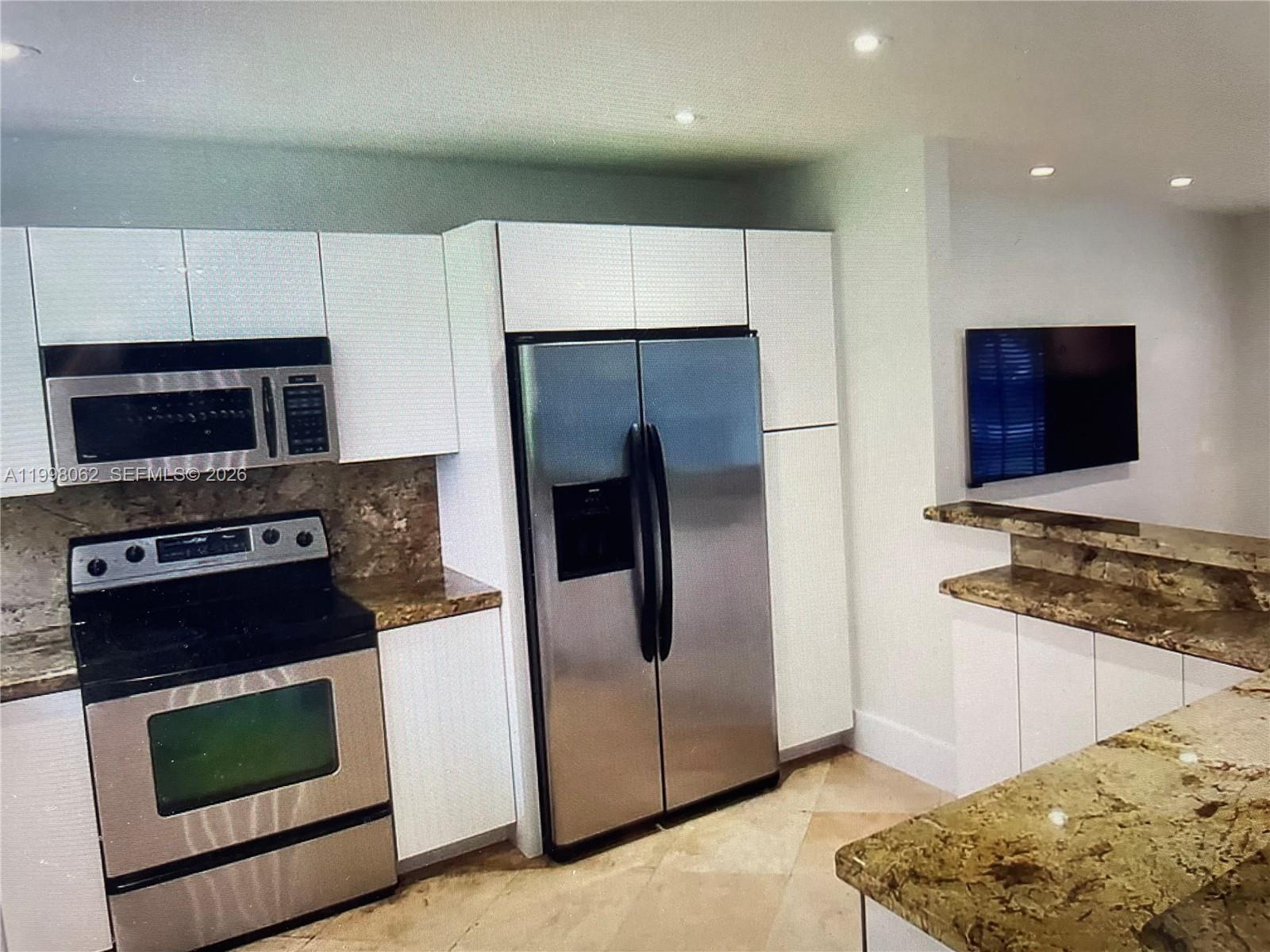 10900 Southwest 107th Avenue Miami, FL 33176 - Photo 4 of 26 a kitchen with stainless steel appliances granite countertop a refrigerator stove and microwave