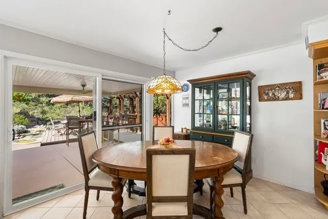 a dining room with furniture a chandelier and wooden floor