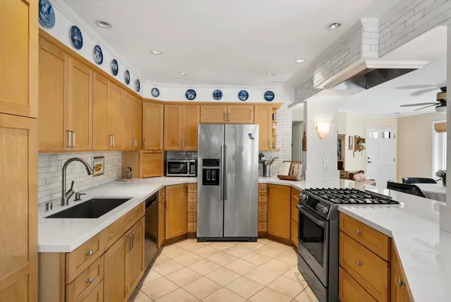 a kitchen with stainless steel appliances granite countertop a sink stove and refrigerator