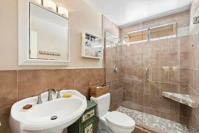 a bathroom with a sink a toilet and shower