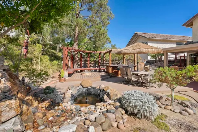 a view of a patio with table and chairs under an umbrella