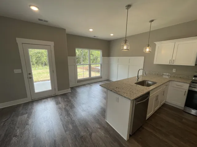a kitchen that has a sink a stove and wooden floor