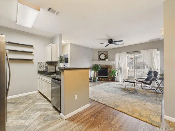a view of a livingroom with furniture a chandelier and wooden floor