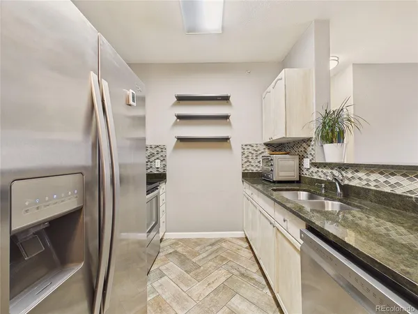 a kitchen with stainless steel appliances granite countertop a sink and cabinets