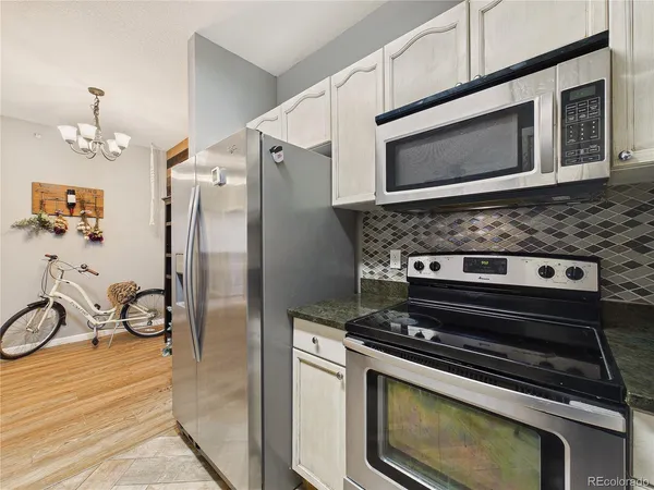 a kitchen with stainless steel appliances granite countertop a sink a stove and a refrigerator