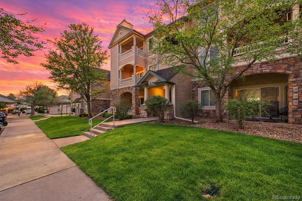 a view of a house with a backyard and a tree