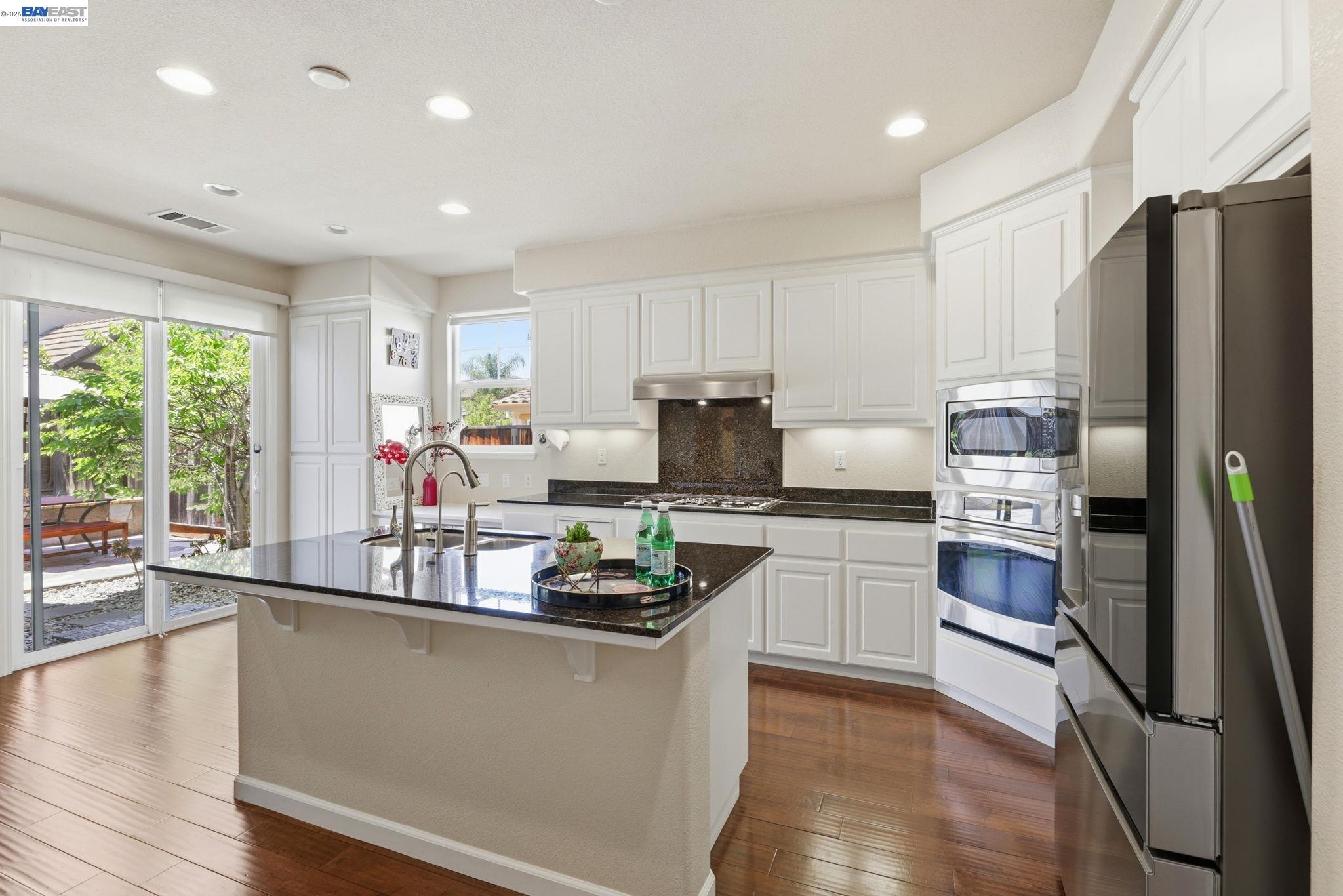 5029 Queensbury Way San Ramon, CA 94582 - Photo 9 of 58 a kitchen with kitchen island granite countertop a refrigerator stove top oven and sink