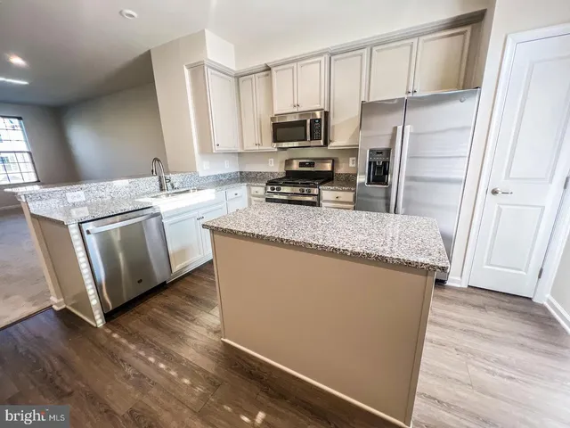 a kitchen with stainless steel appliances granite countertop a refrigerator stove microwave and sink