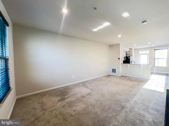 an empty room with a kitchen and a sink