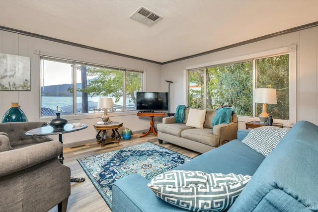 a living room with fireplace furniture and a large window