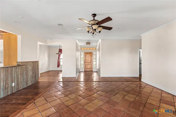 a view of a livingroom with a dinning area hardwood floor and a ceiling fan