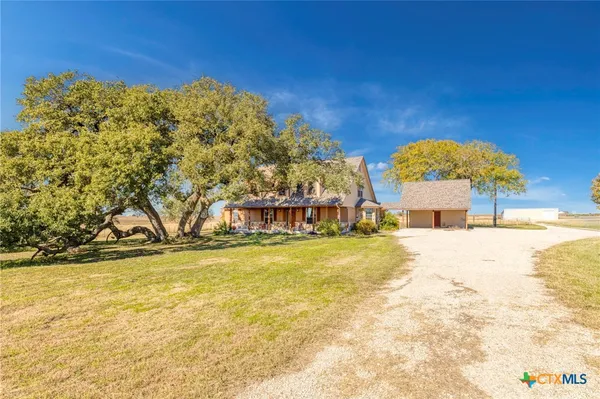 a view of a swimming pool with a lawn chairs under an umbrella and yard