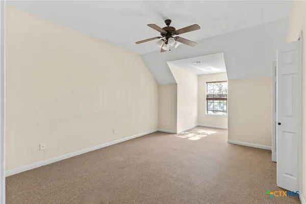a view of a big room with windows and chandelier fan