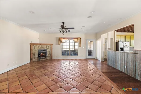 a view of a livingroom with wooden floor and a kitchen