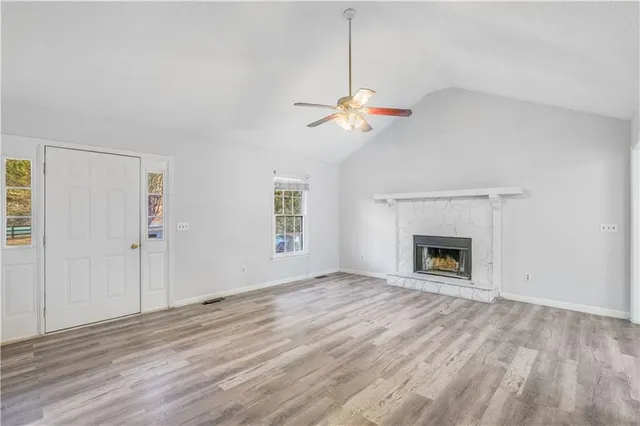 a view of an empty room with a fireplace and a window