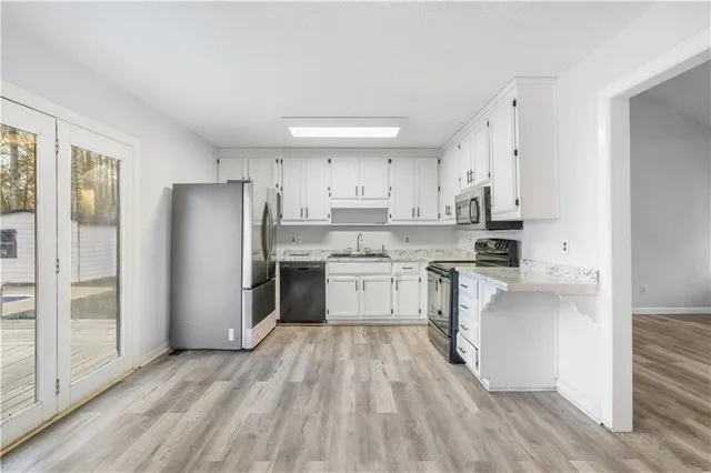 a kitchen with stainless steel appliances a refrigerator and a stove top oven
