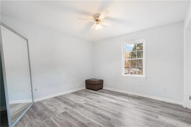 an empty room with a ceiling fan and a window