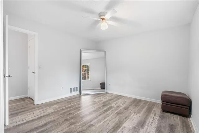 a view of a livingroom with wooden floor and a ceiling fan