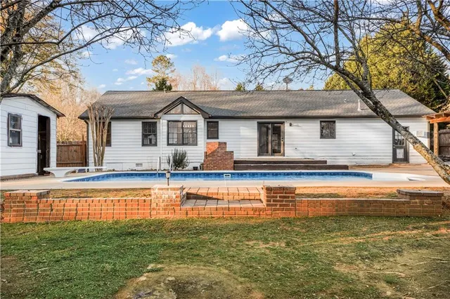 a front view of a house with swimming pool and porch