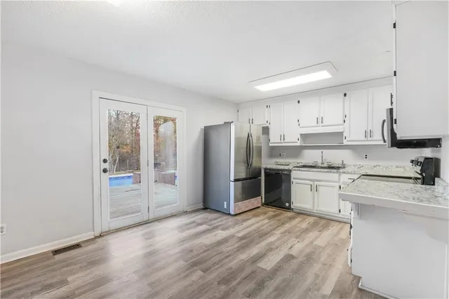 a kitchen with a refrigerator sink and cabinets