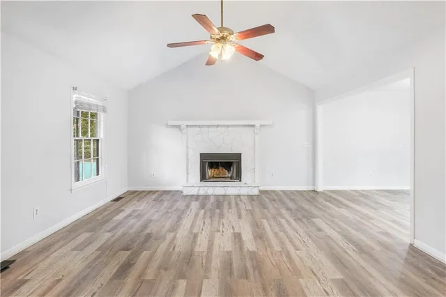 an empty room with windows and a fireplace