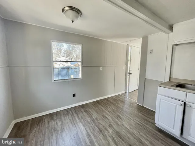 a view of a kitchen with wooden floor and a window