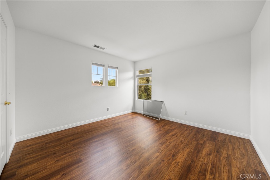8679 Cabin Place Riverside, CA 92508 - Photo 15 of 35 an empty room with wooden floor and windows