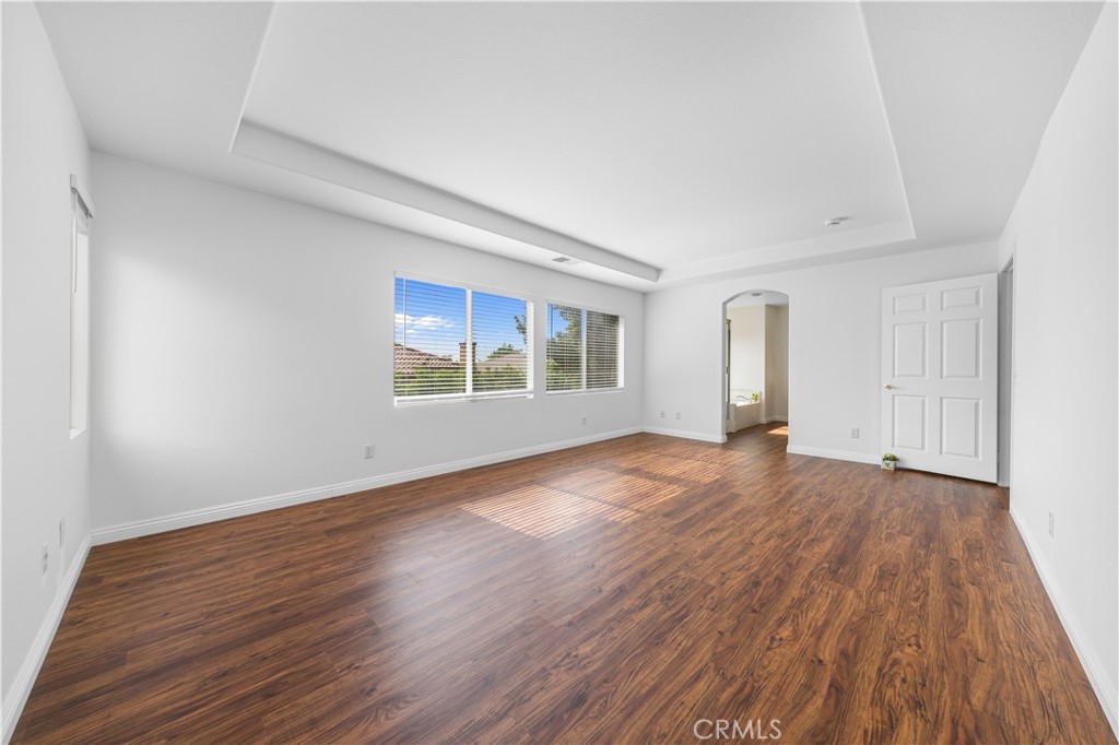8679 Cabin Place Riverside, CA 92508 - Photo 30 of 35 an empty room with wooden floor and windows