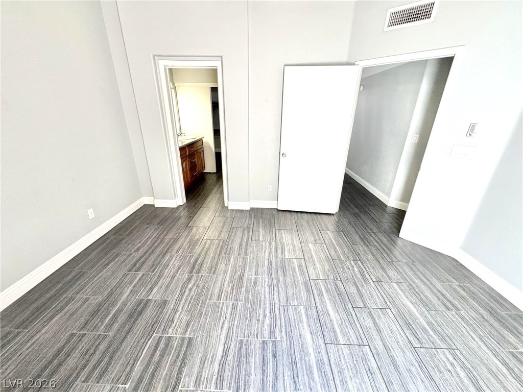 5304 Runningbrook Road Las Vegas, NV 89120 - Photo 7 of 22 Durable tile flooring stretches across a versatile bedroom featuring smooth walls and clean baseboards.
