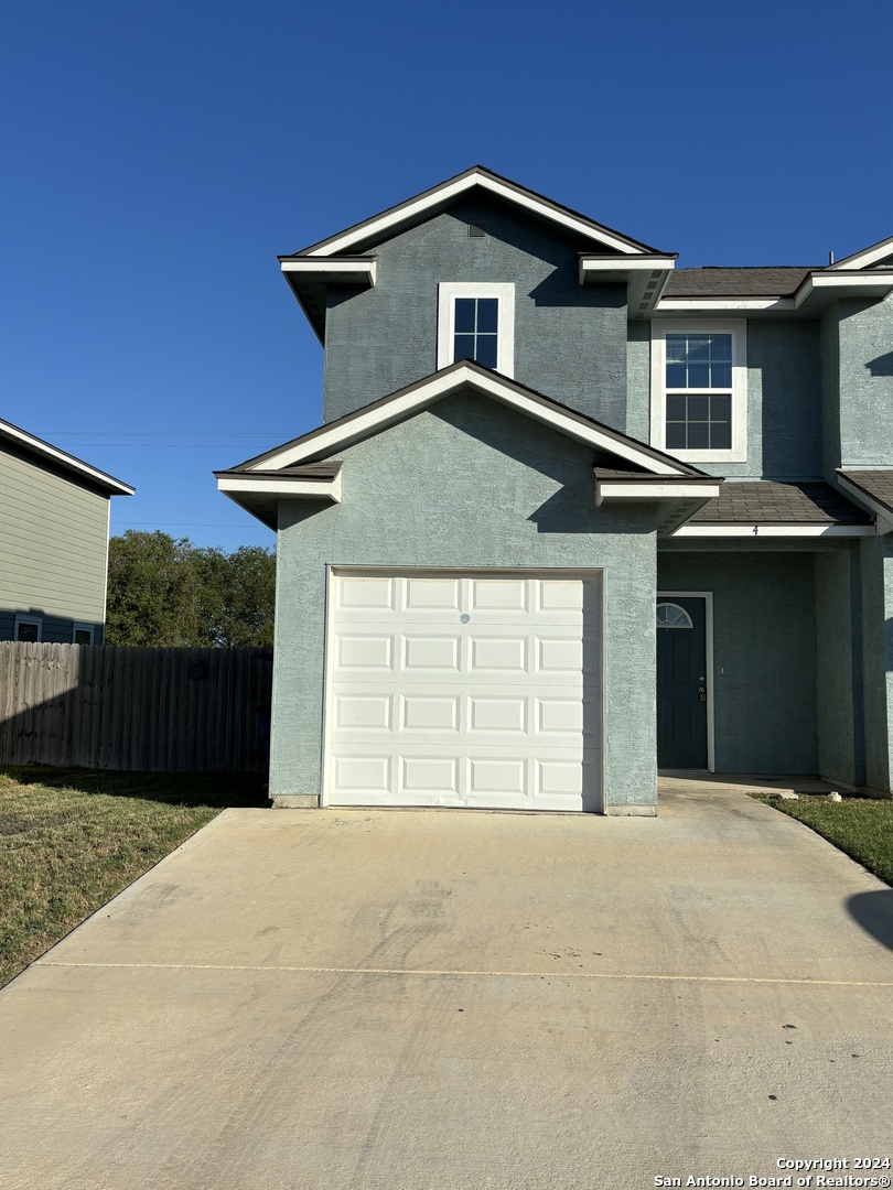 8327 Breezy Cove, Unit 2 Selma, TX 78154 - Photo 2 of 13 a front view of a house with a yard and garage