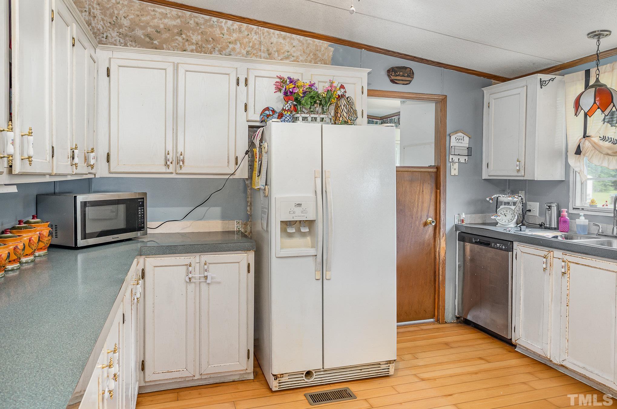 6301 Sandy Creek Road Stedman, NC 28391 - Photo 13 of 27 a kitchen with a refrigerator a stove a sink and a cabinets
