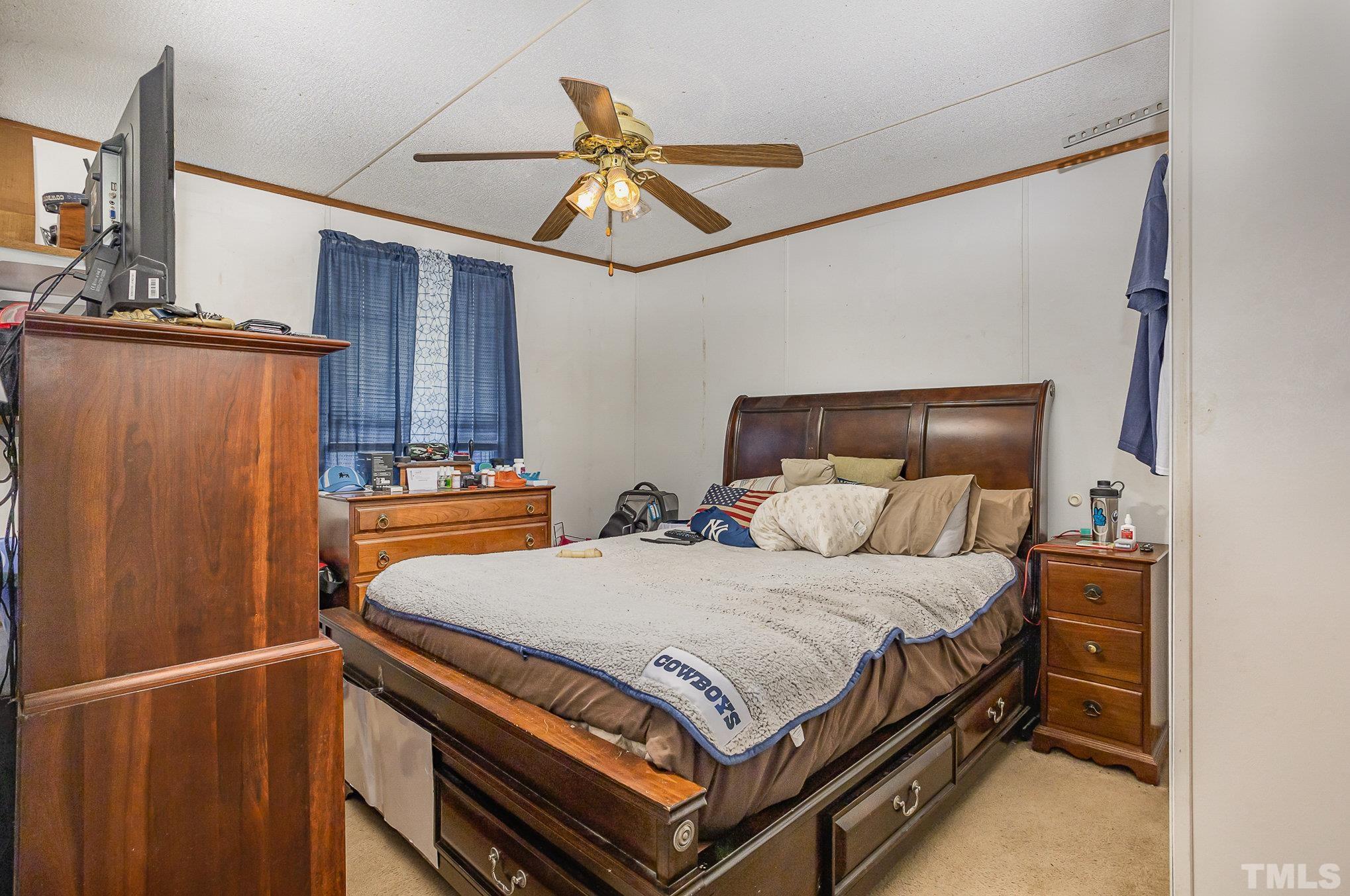 6301 Sandy Creek Road Stedman, NC 28391 - Photo 21 of 27 a bedroom with a bed and a chandelier