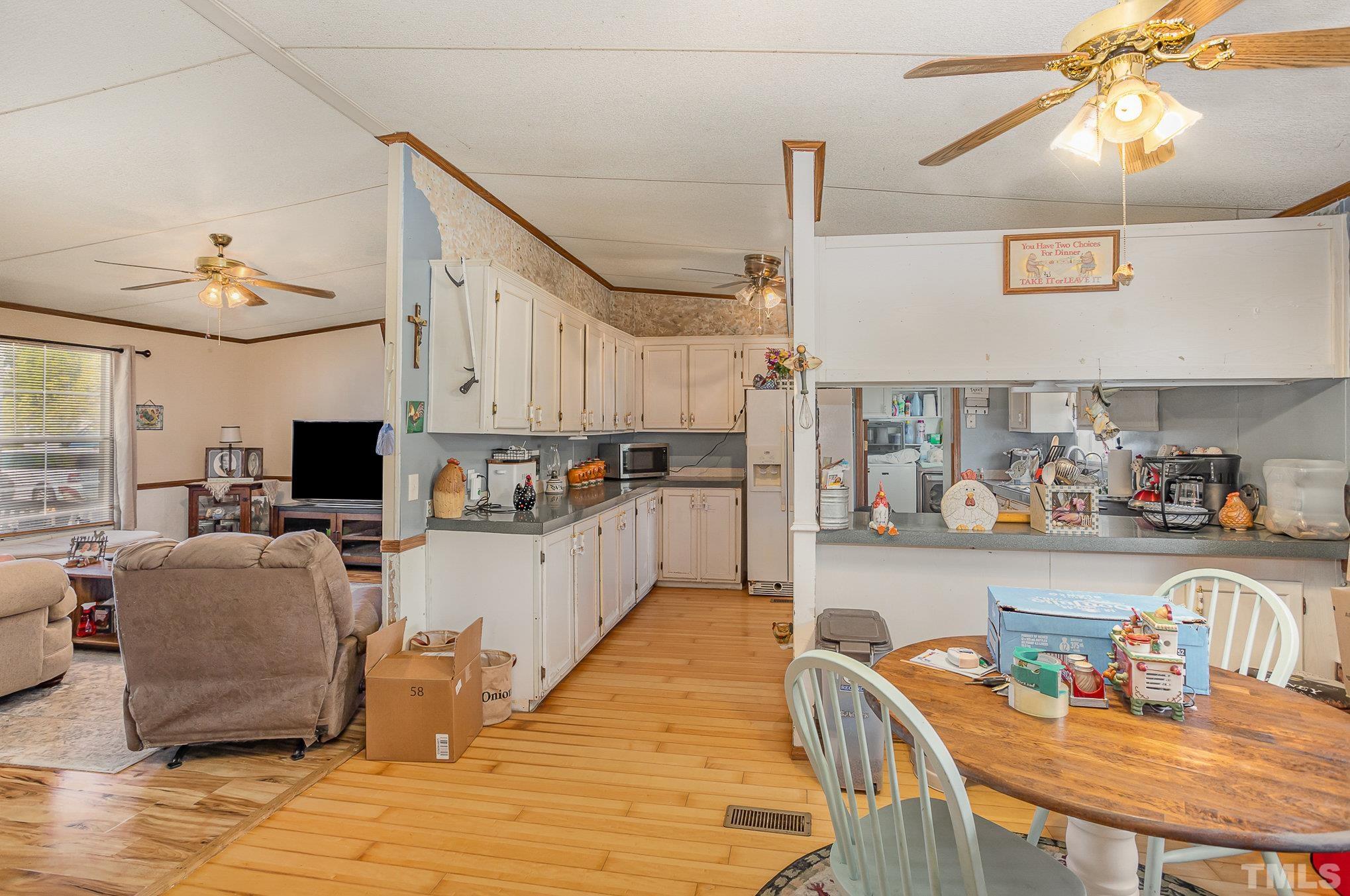 6301 Sandy Creek Road Stedman, NC 28391 - Photo 10 of 27 a kitchen with stainless steel appliances granite countertop a stove top oven a sink a dining table and chairs with wooden floor