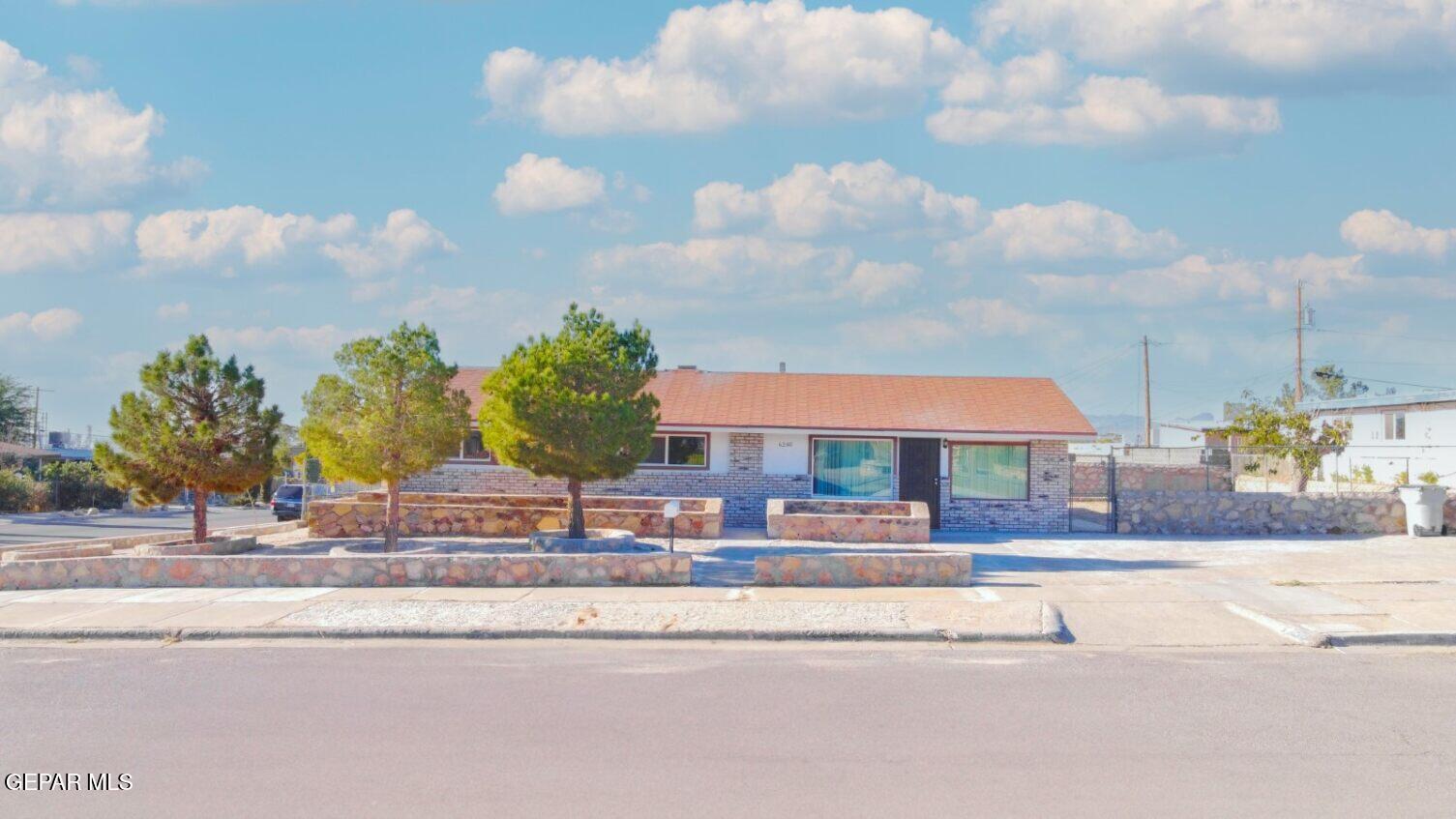 a front view of a house with a garden and pathway