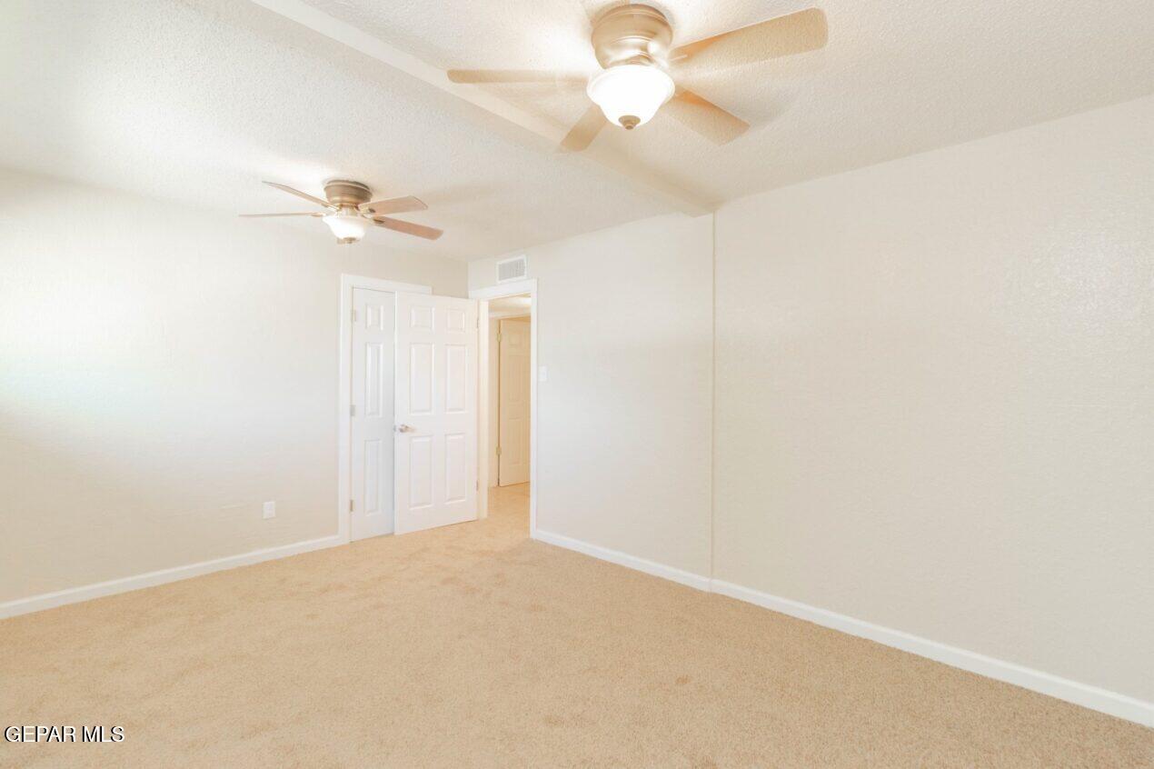 6240 Cibolo Court El Paso, TX 79905 - Photo 19 of 50 an empty room with a chandelier fan and windows