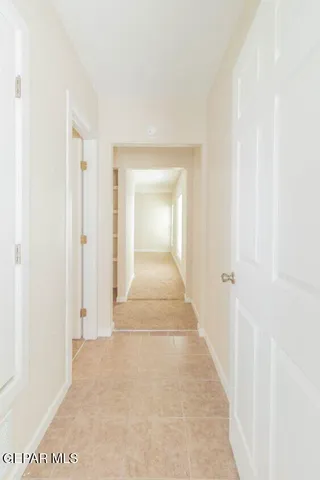 a view of a hallway with wooden floor and a bathroom
