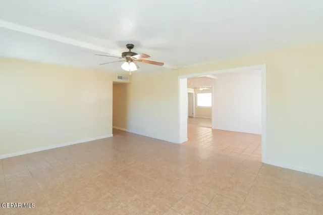 a view of an empty room with a ceiling fan
