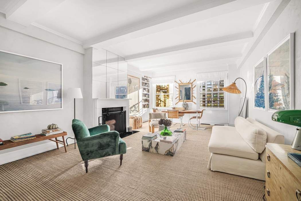 a living room with furniture fireplace and a large window