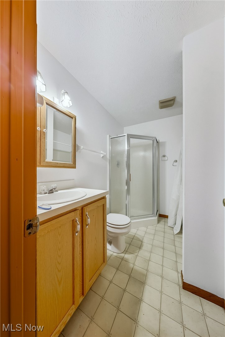 425 Overlook Drive Rittman, OH 44270 - Photo 30 of 44 Full bath featuring a stall shower, vanity, light tile patterned floors, and a textured ceiling