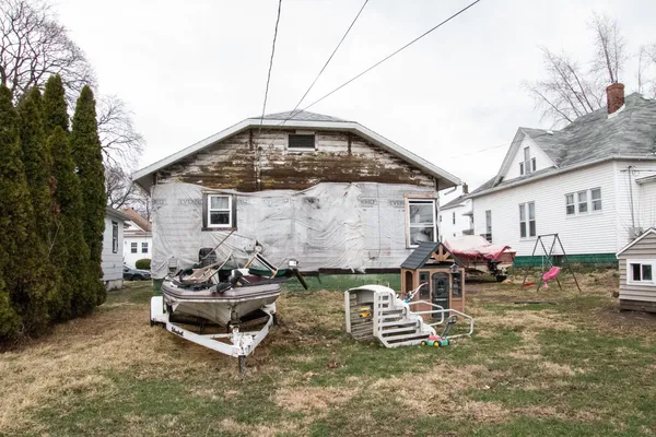 a view of a big house with a big yard and large trees