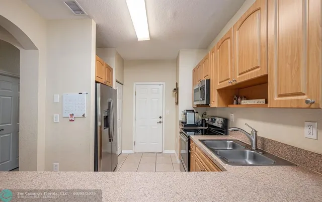 a kitchen with granite countertop a refrigerator stove top oven and sink